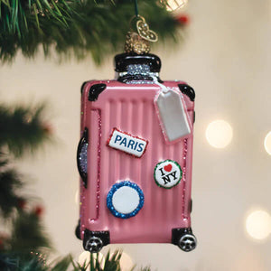 Pink glittery glass suitcase ornament with black trim wheels handle and paris and i love ny travel stickers