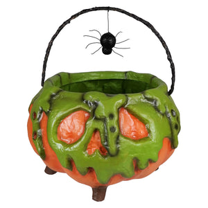 Poison pumpkin cauldron filled with colorful halloween candy and a decorative black spider on the side