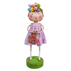 Whimsical decorative figurine wearing a pink striped dress with colorful baubles on its head and a butterfly accent.