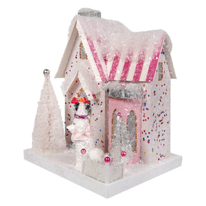 A festive pink and white candy house ornament with glittery snow and striped roof from cody foster poodle palace collection