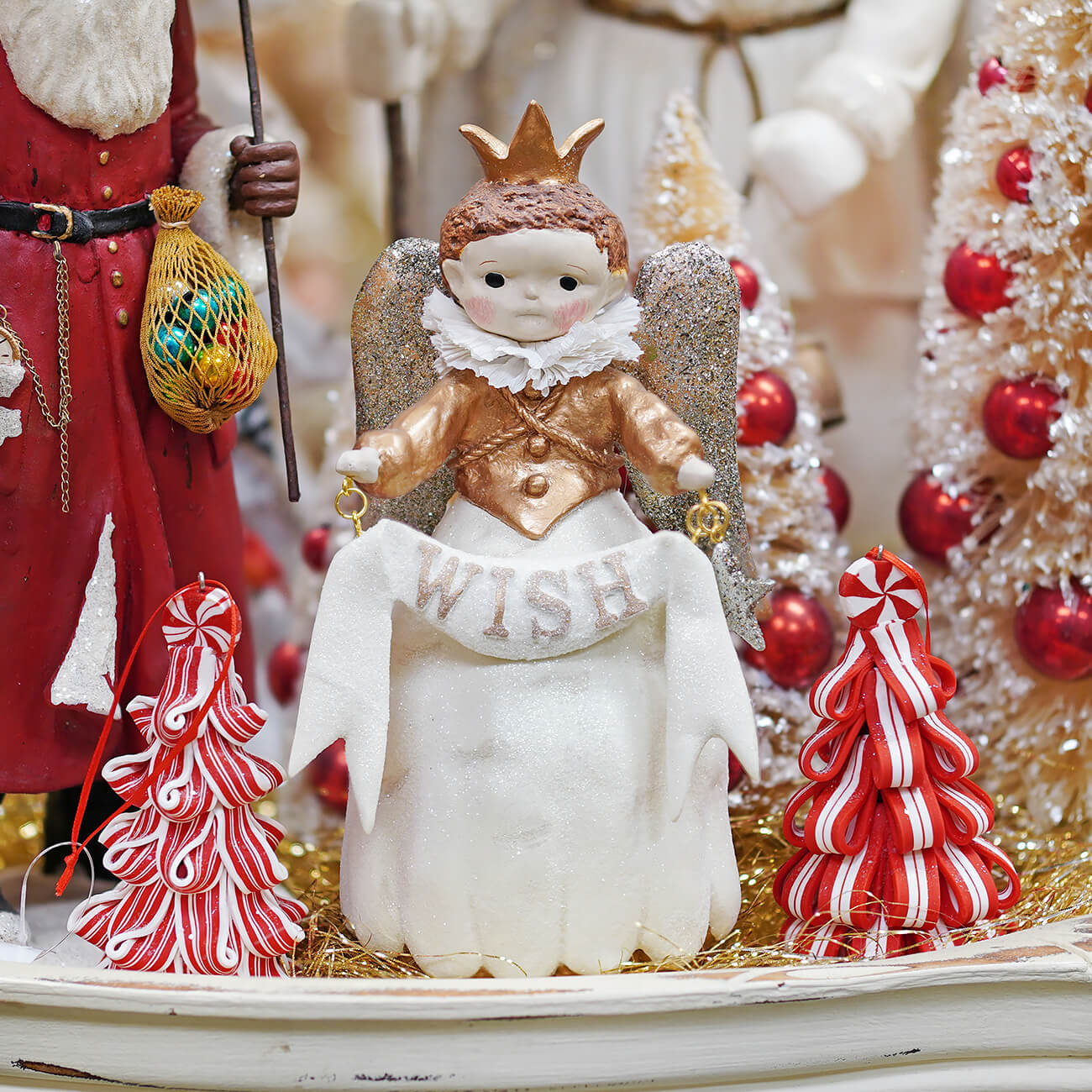 A princess wish angel figurine with a gold crown silver glitter wings and white ruffled collar holding a wish banner