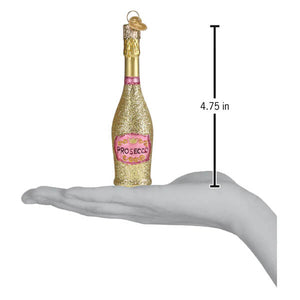 A glittering gold prosecco bottle ornament with a pink label and foil-wrapped cork christmas glass ornament