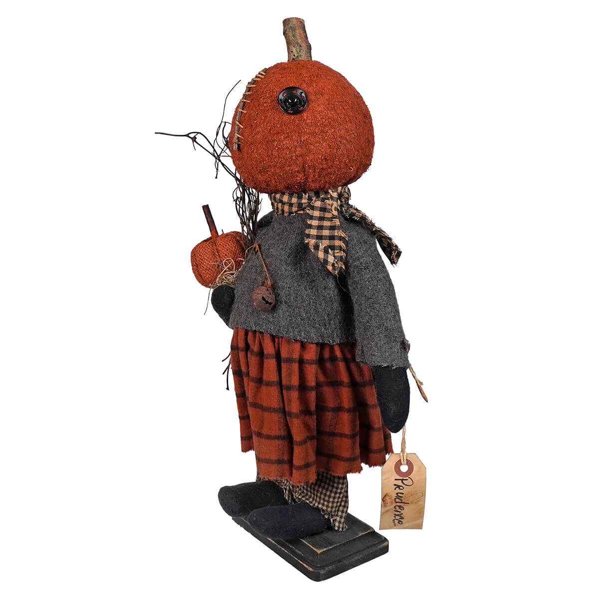 Whimsical pumpkin-headed doll figure wearing a plaid skirt and gray jacket.