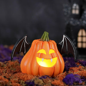 Orange pumpkin bat luminary with black wings and glowing yellow face made of hand-painted resin by bethany lowe design
