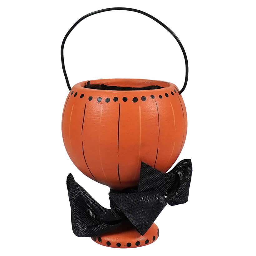 Orange pumpkin-shaped candy bucket with a black bow decoration and handle.