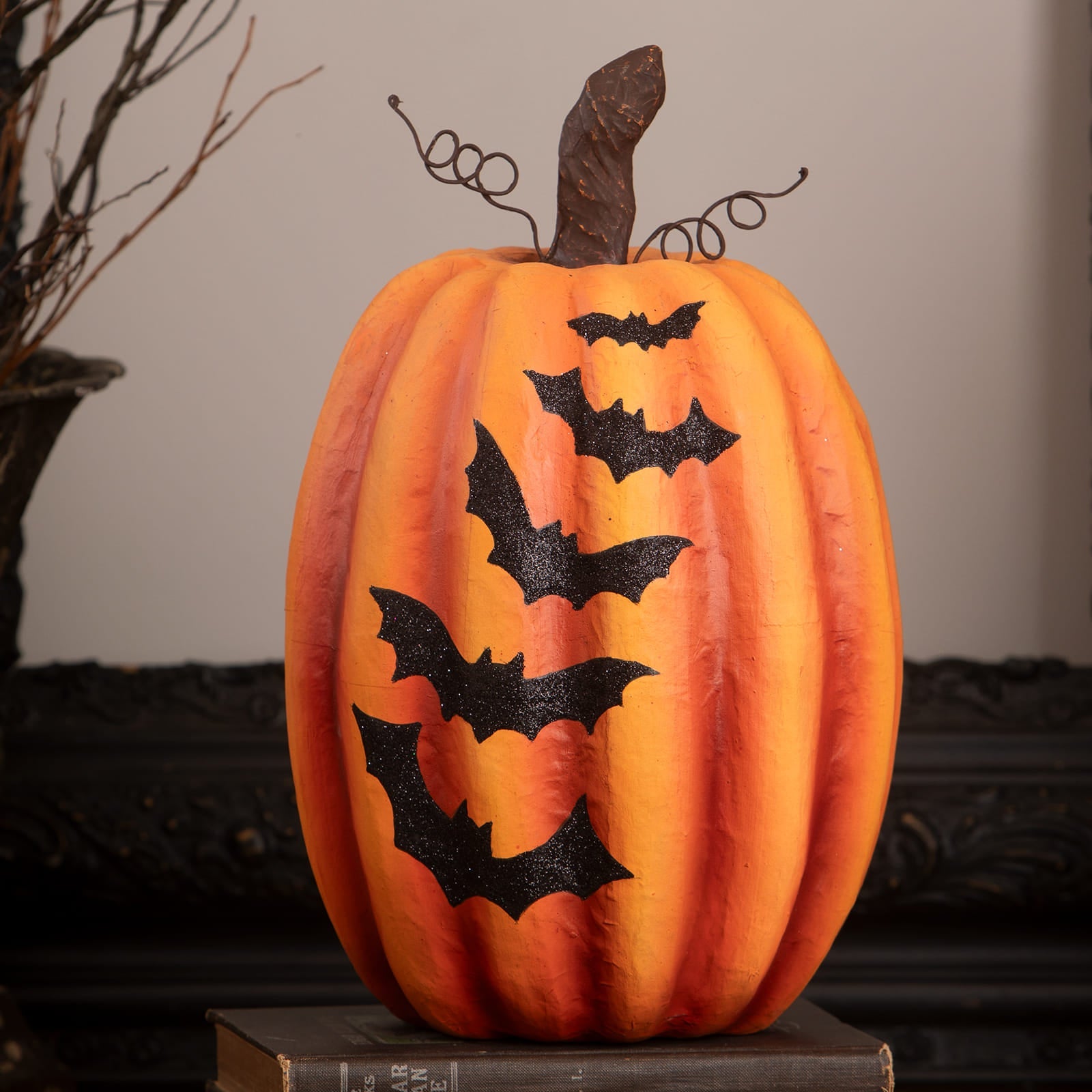 Orange halloween pumpkin with black glitter bats and dark brown twisted stem halloween pumpkins and gourds