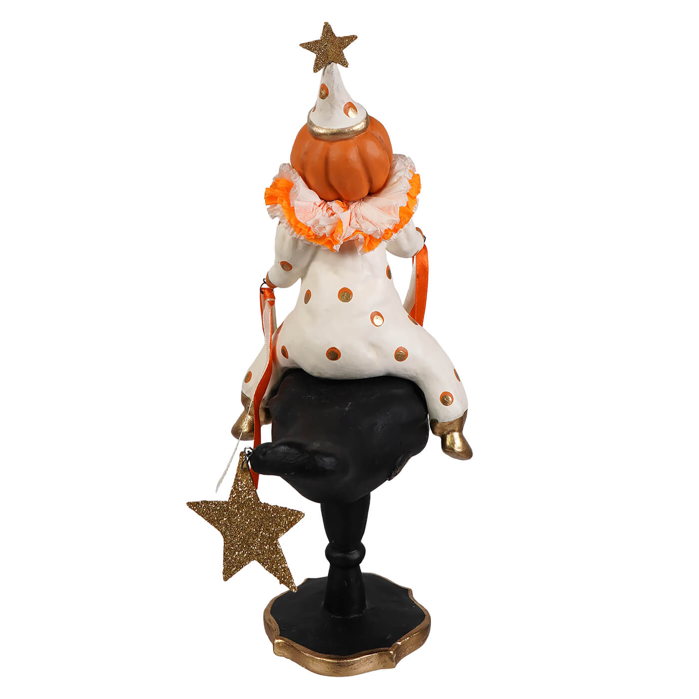 A whimsical halloween figurine of a pumpkinhead on crow with an orange jack o lantern head and polka-dotted outfit