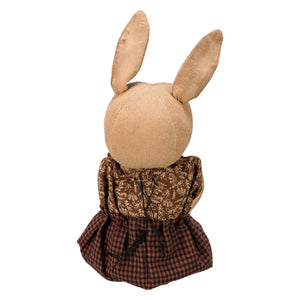 A plush rabbit egg doll with tan fabric ears wearing a brown floral top and dark red plaid skirt