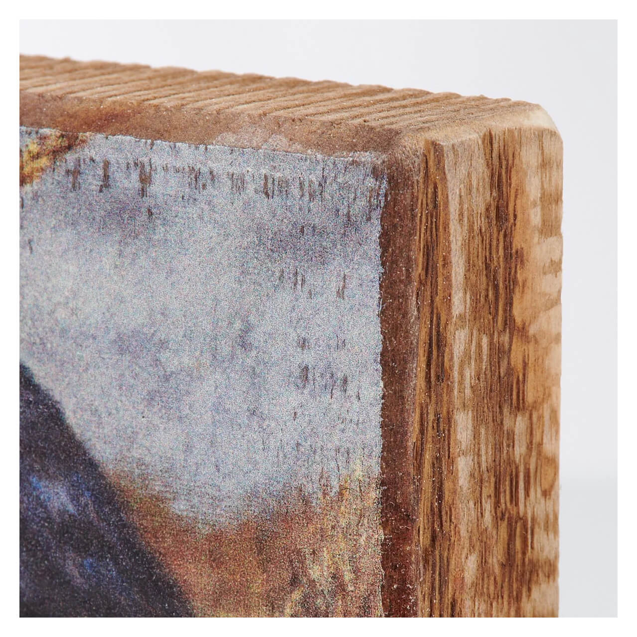 Corner of a wooden block or beam with visible grain and a painted or treated surface.