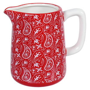 Red ceramic pitcher with white floral paisley pattern.