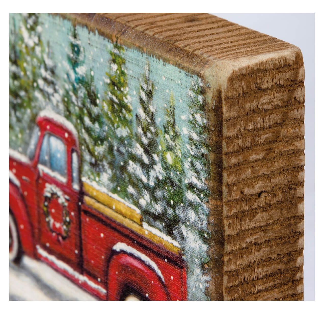 Painted wooden block featuring a vintage red truck in a snowy pine forest scene.