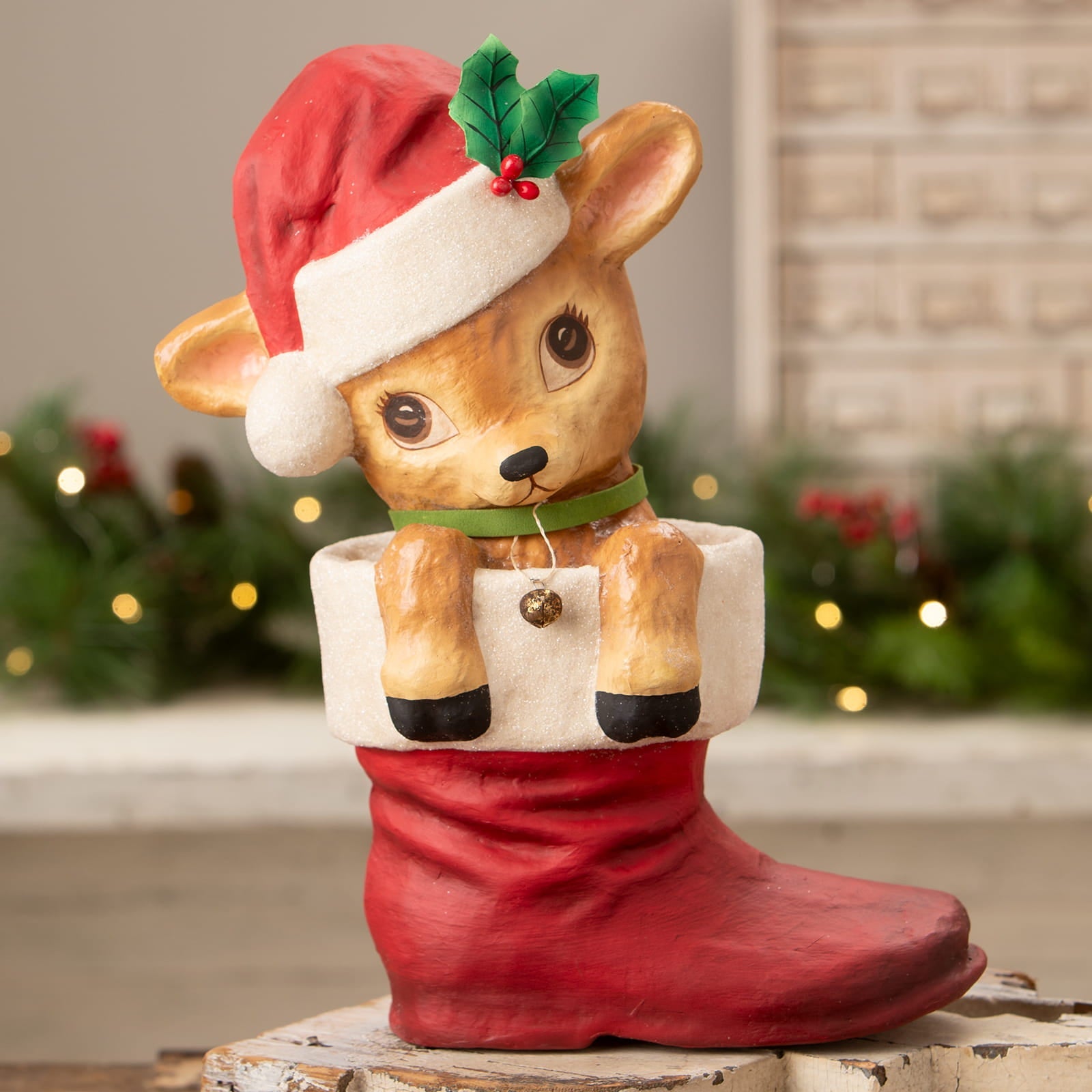 A charming bethany lowe design reenie reindeer ceramic figure with santa hat in a red christmas stocking decor