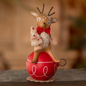 A charming beige reindeer on a glossy red ornament with white swirls by bethany lowe designs christmas reindeer figures ornaments & decor