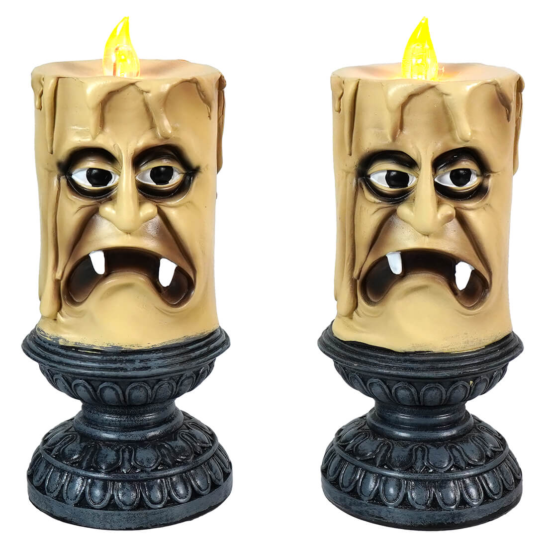 Spooky decorative candles shaped like grimacing faces with fangs and glowing yellow flames.