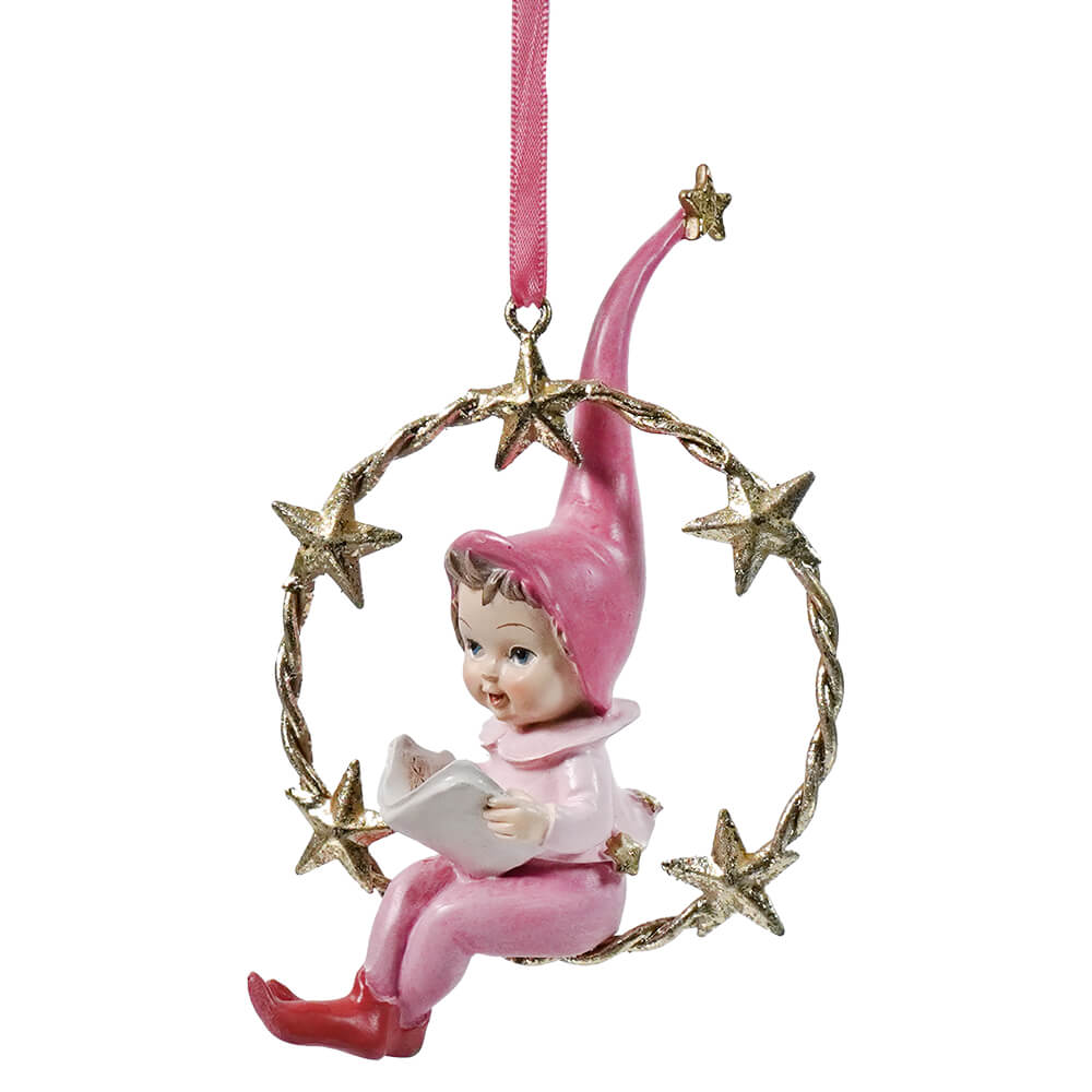 Pink ceramic resin swinging pixie ornament holding book with gold finish and star accents, hanging by pink ribbon