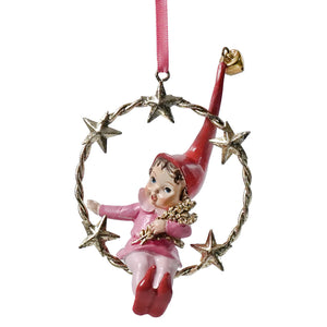 A resin swinging pixie ornament with pink elf, red hat, gold finish stars, in twisted metal wreath with silver stars
