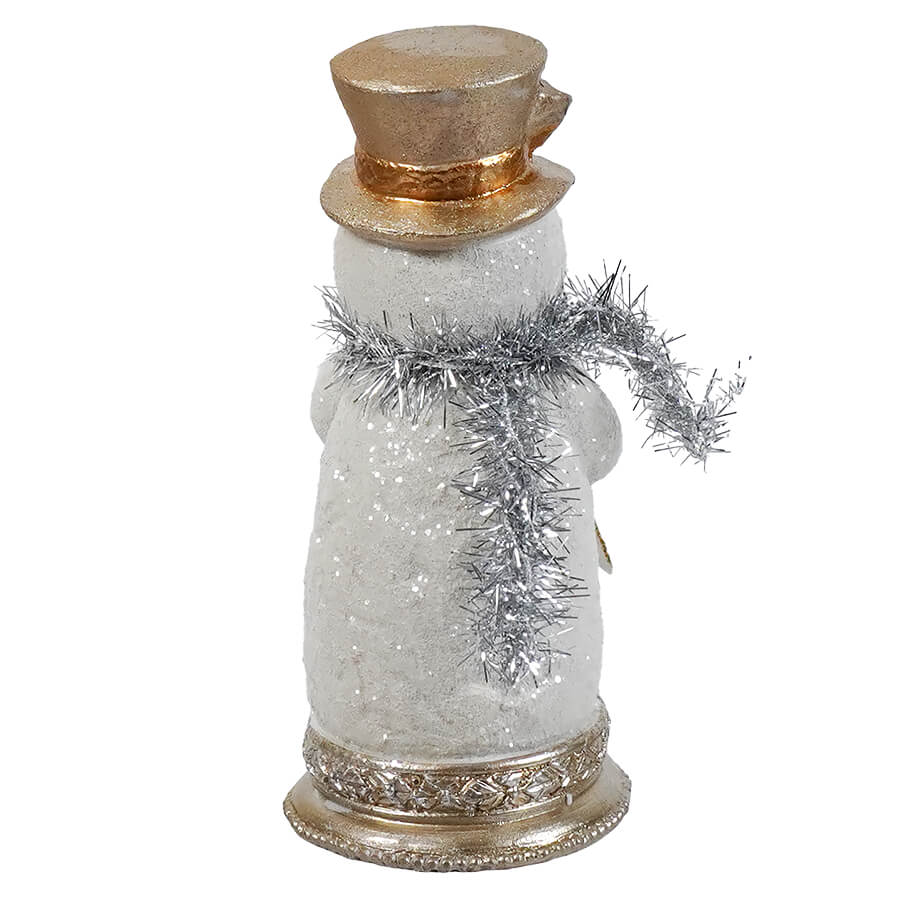 A glittering white resin tinsel snowman figurine with gold top hat and silver scarf on ornate metallic base christmas decor