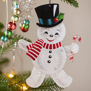 A glittery white bethany lowe design retro rockin snowman ornament with black top hat and candy cane accessory