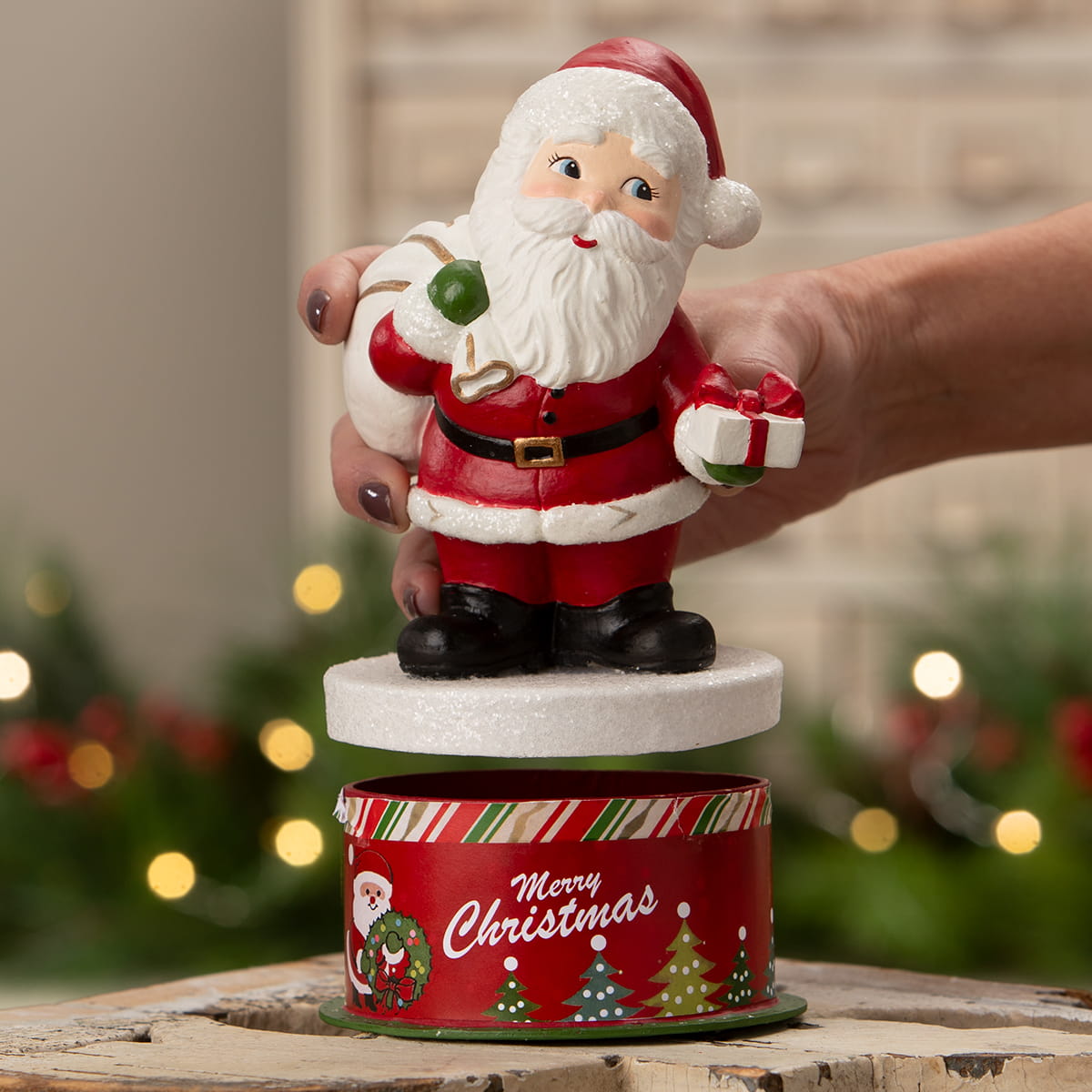 Red and white retro santa figurine by bethany lowe design holding green ornament and wrapped gift in black boots