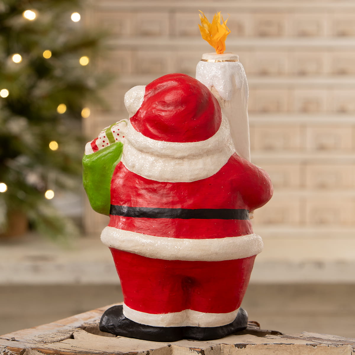 Retro santa bethany lowe design figurine in red and white holding green gift bag with candle on wooden stump base
