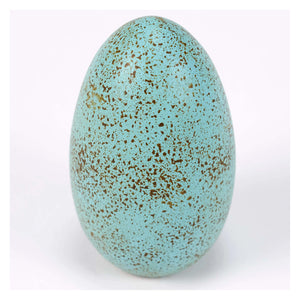 A matte turquoise robin egg with brown and gold speckles perfect for easter bunny tabletop decor and decorative grass