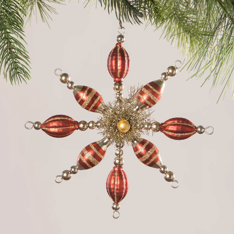 Ornate star-shaped Christmas tree ornament with red and gold glass beads.