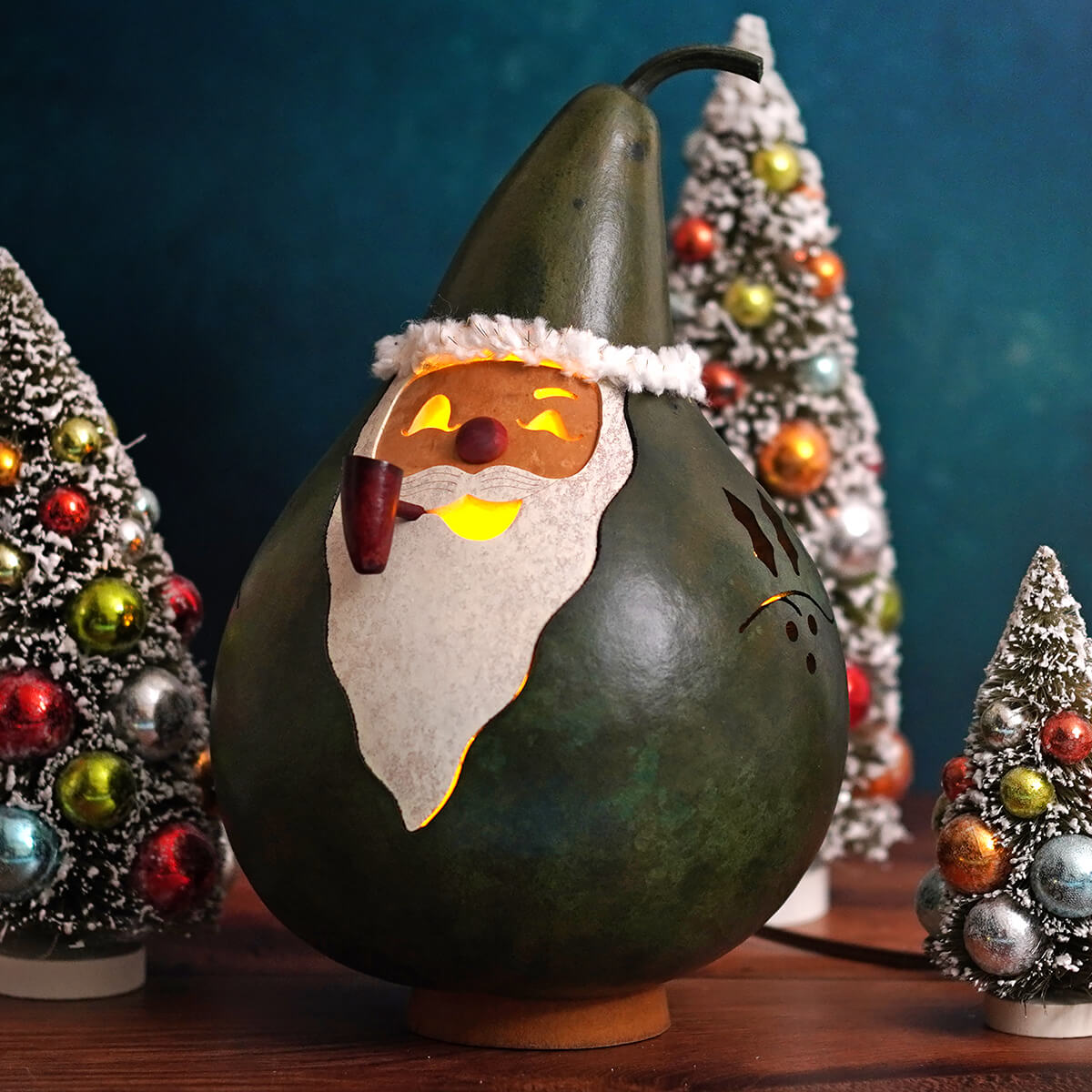 Lighted santa gourd carved from dark green gourd shaped like santa with white beard and pipe by meadowbrooke gourds