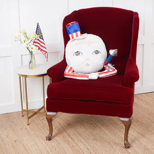 A plush white mooncake-shaped sammy baby zombinaland decorative pillow by tracy scheff with an american flag hat and silver trumpet