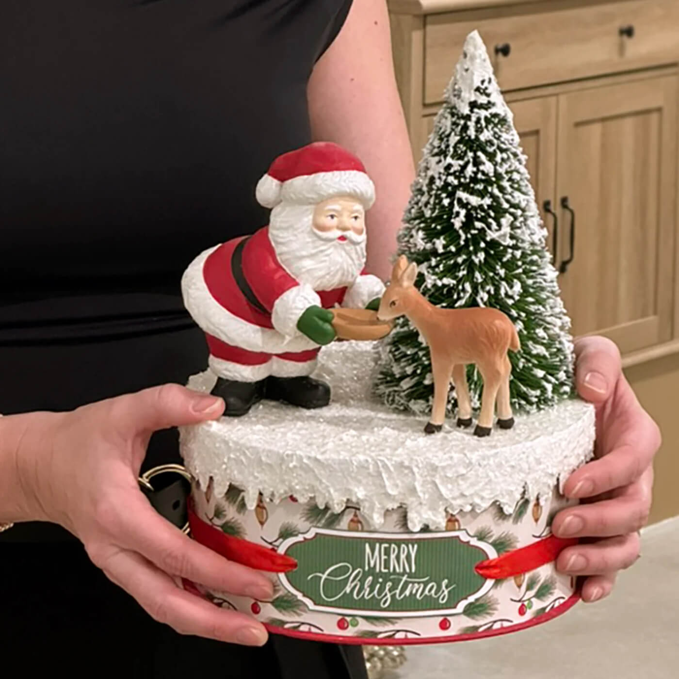 A festive bethany lowe design santa figures and folk art santas cake with red santa feeding a christmas reindeer figure