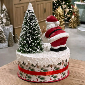 Red and white bethany lowe design santa figure with black boots on frosted tree atop festive holiday cake decor
