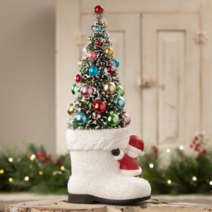 A festive bethany lowe design santa boot with tree featuring colorful ornaments and a glittery white base