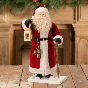 Red and white plush santa figure by bethany lowe designs holding a lantern and walking stick santa lights the way