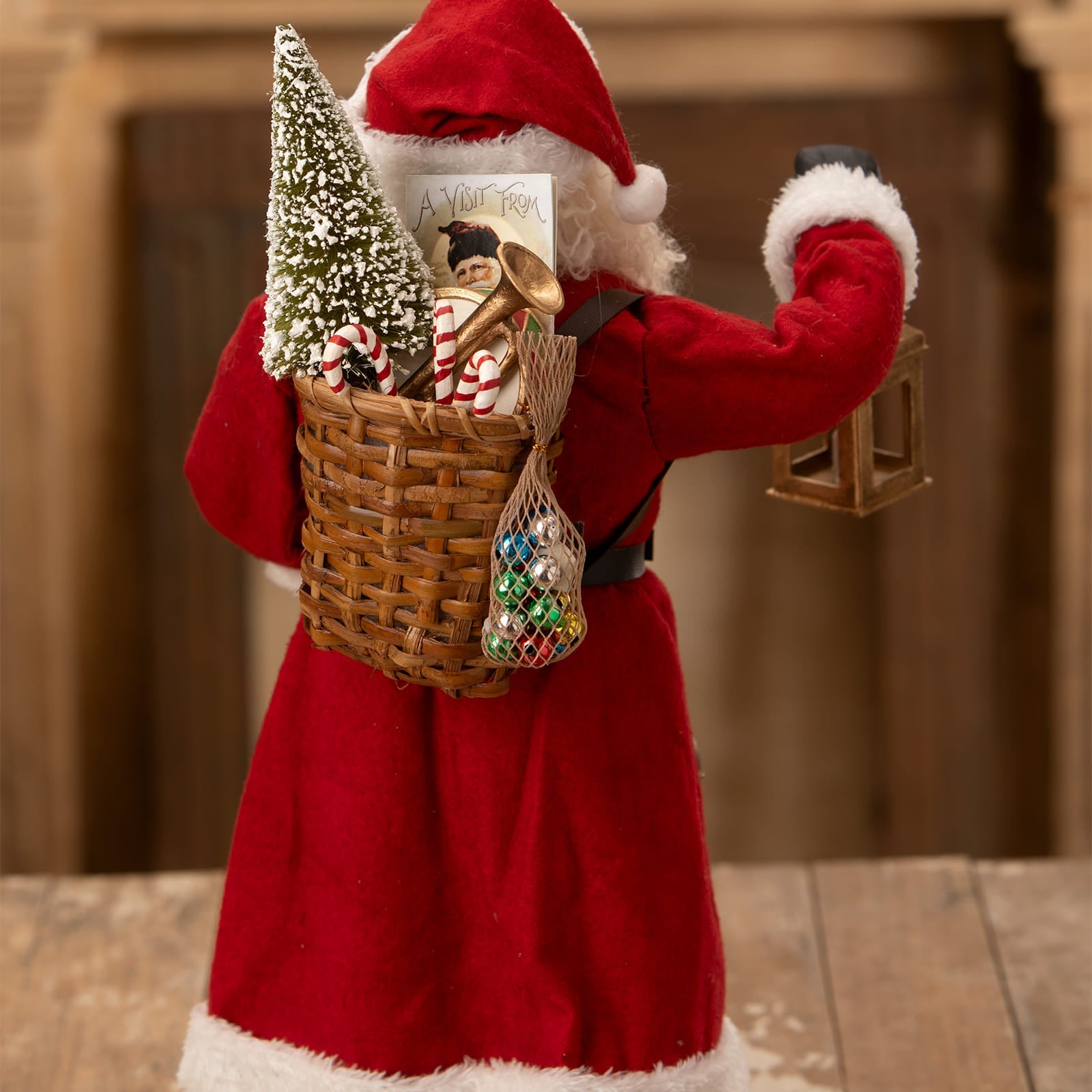 Red velvet santa figure with white fur trim carrying a wicker basket of decorations from bethany lowe designs santa figures