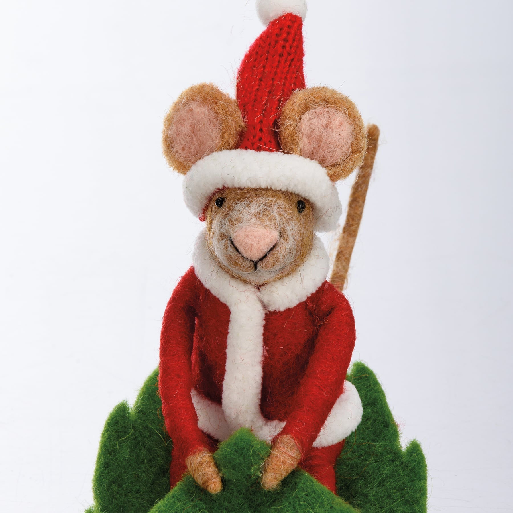 A merry mouse critter needle-felted in a red and white santa suit with knit hat on green felt foliage