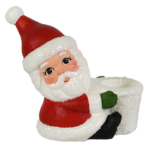 Red and white glittery santa taper candle holder by bethany lowe design with green gloved hand holding planter