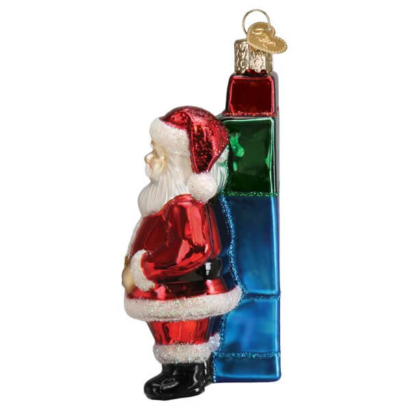 Red and white glass santa’s ai bot christmas glass ornament leaning against a multi-colored gift box