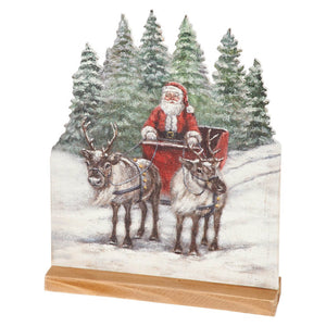 Christmas-themed wooden santa claus stand with vintage santa claus riding sleigh pulled by reindeer in snowy pine forest