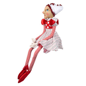 A charming red and white polka-dotted christmas elf doll named sayra spreading holiday cheer in spencer’s gathered traditions