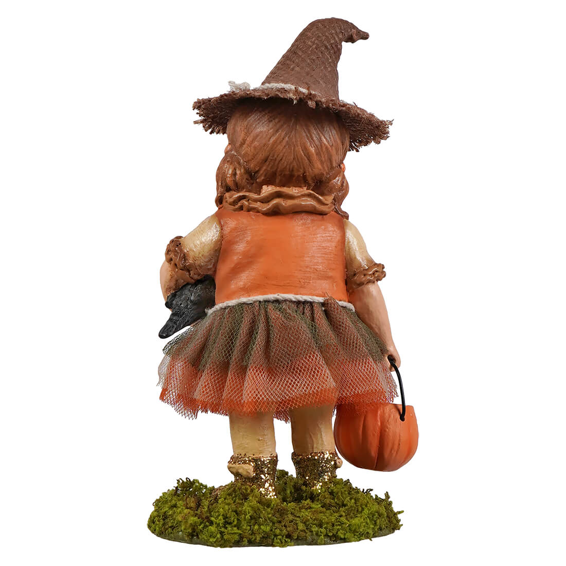 A miniature halloween scarecrow witch figurine with a brown hat orange vest and tulle skirt holding a pumpkin basket