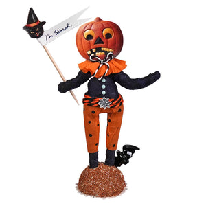 Handcrafted folk art scared pumpkin figure with orange head, black polka-dot pants, and paper mache holding i’m scared sign