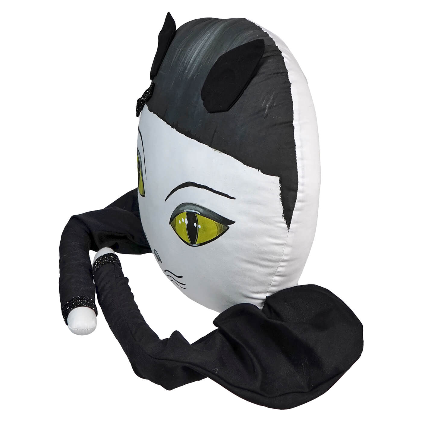 Plush toy or stuffed animal resembling a stylized cat head with one visible green eye.