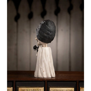 A white textured skeleton figurine with black hair in a wedding dress holding a black rose shelley skelly