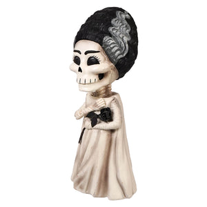 A whimsical shelley skelly skeleton figurine dressed as a vintage bride with black lace-up hair holding a black rose