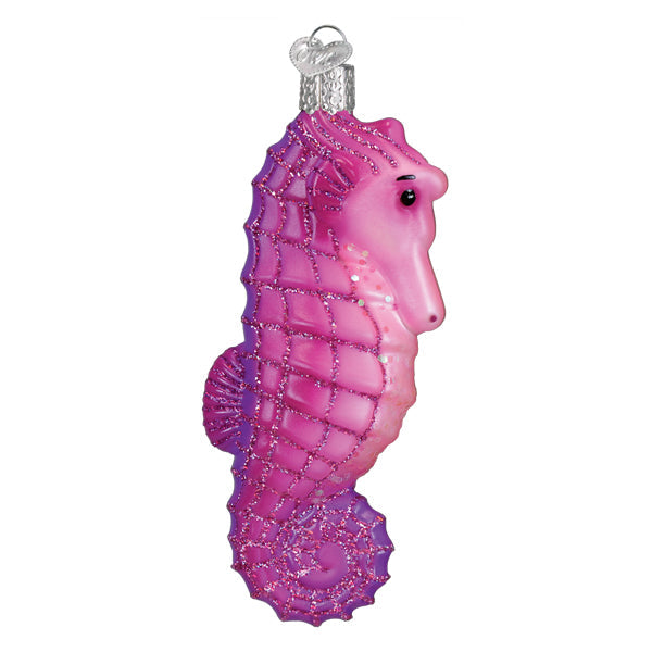 A bright seahorse ornament made of pink and purple glittery glass with a silver hanging loop perfect for animal ornaments