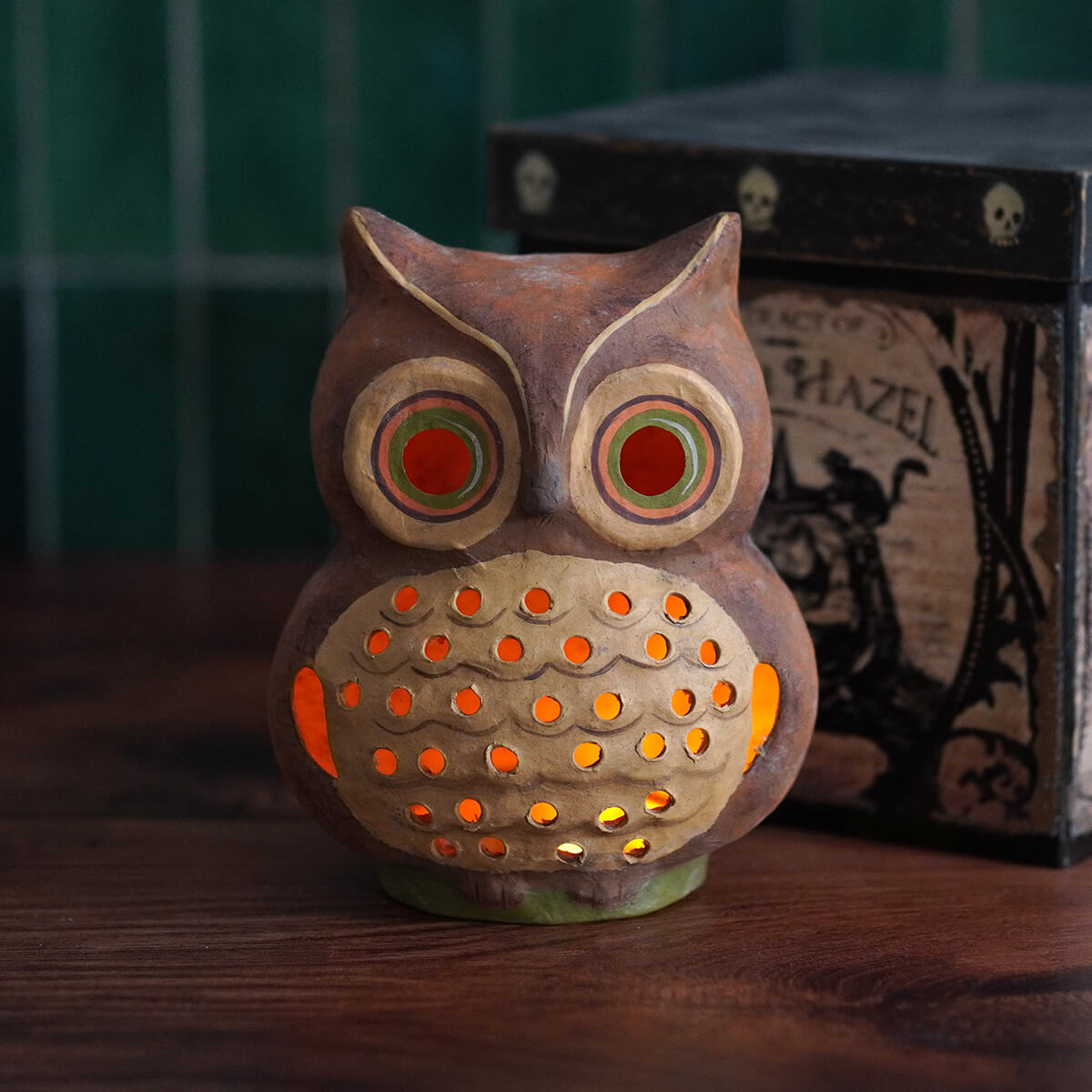 A rustic brown ceramic shining bright owl lantern with glowing orange chest lights and colorful eyes by bethany lowe design