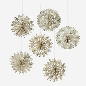 Silver cutout snowflake ornaments made of metallic paper hanging from strings in a snowflake ornaments boxed set 6