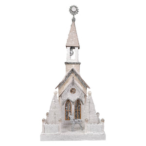 A delicate white and silver glittery cody foster silver steeple church figurine with frosted pine trees and light cord