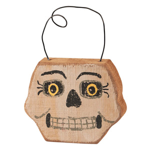 A rustic wooden skeleton face chunky hanging basket with painted yellow eyes and gray teeth by phil chapman design