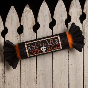 Black glittery candy wrapper with orange fuzzy ends labeled sugar candy skulls featuring skull icons for bethany lowe halloween candy