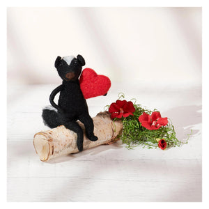 Black felt skunk critter ornament with white markings holding a red heart valentine skunk gift idea